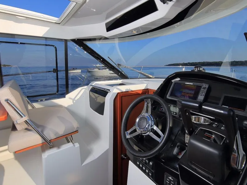 Slide: The Image of 2024 Jeanneau NC 895 boat interior with modern helm and ocean view. - 14