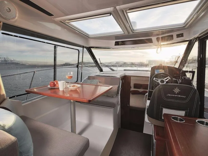Slide: The Image of Interior of 2024 Jeanneau NC 895 boat with dining area and helm, overlooking water. - 7
