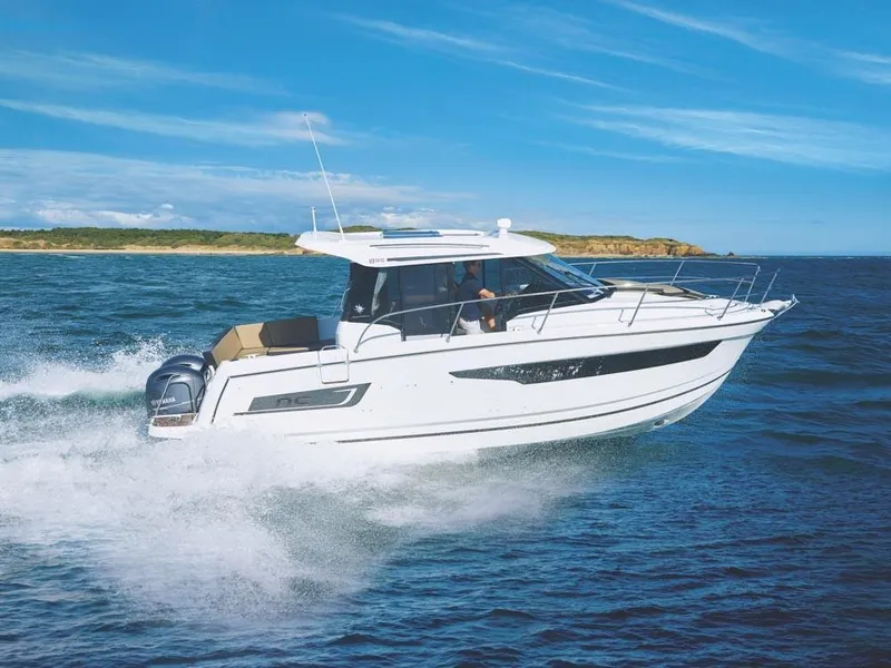 Slide: The Image of 2024 Jeanneau NC 895 cruising on open water under a clear blue sky. - 0