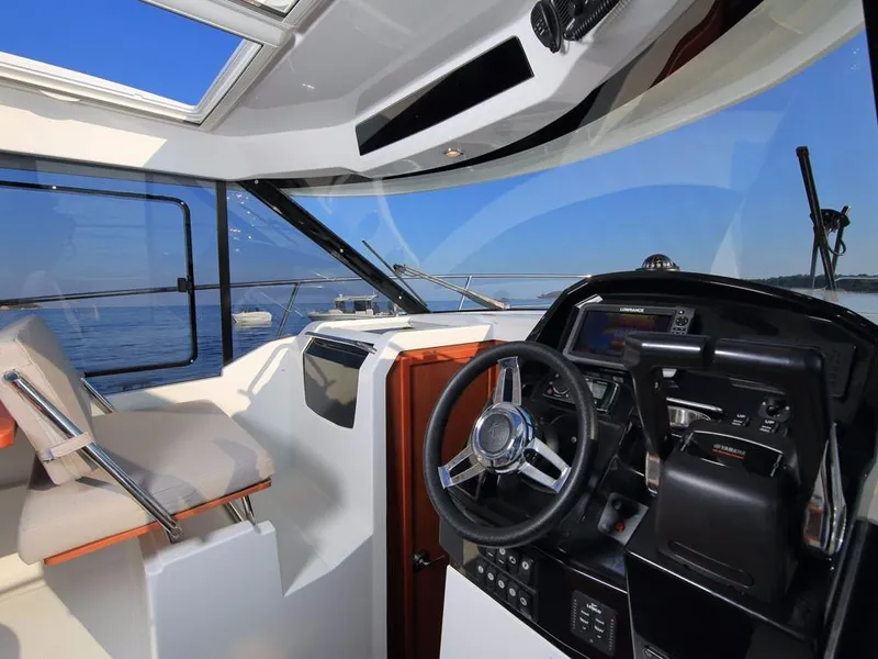 Slide: The Image of 2024 Jeanneau NC 895 helm with modern controls and panoramic sea view. - 13