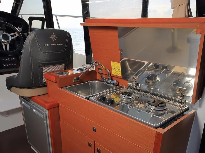 Slide: The Image of 2024 Jeanneau NC 895 boat interior with compact kitchen and steering area. - 8