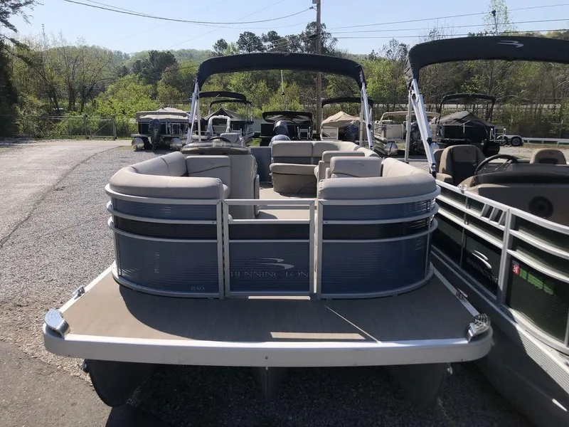 Slide: The Image of 2018 Bennington 22SLX pontoon boat with spacious seating, parked outdoors. - 2