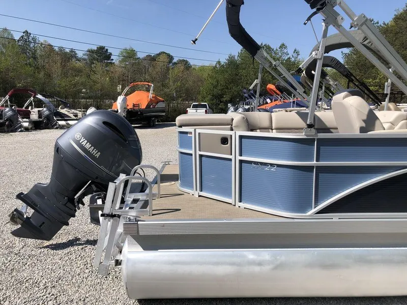 Slide: The Image of 2018 Bennington 22SLX pontoon boat with Yamaha outboard motor, parked on gravel. - 6