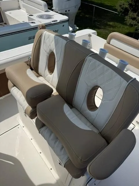 Slide: The Image of 2025 Sea Born LX24 Center Console boat seats with beige and white cushioned design. - 21