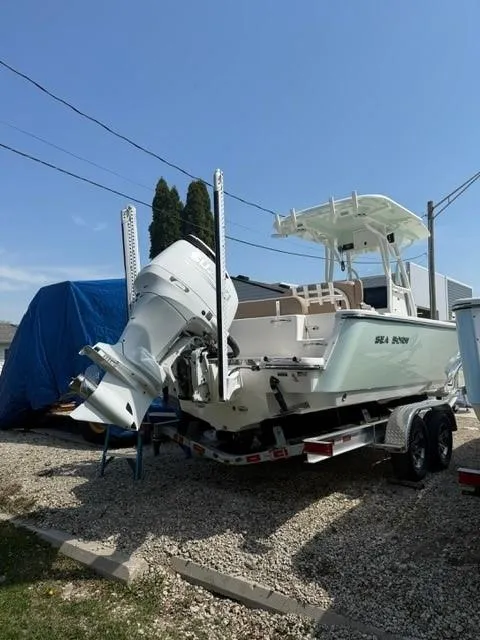 Slide: The Image of 2025 Sea Born LX24 Center Console boat on trailer, parked outdoors. - 22