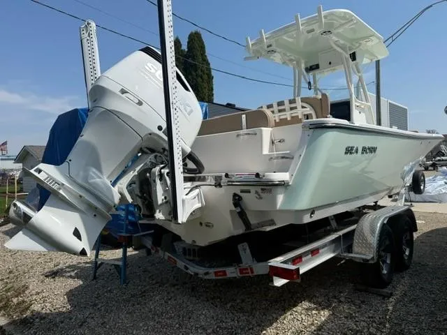 Slide: The Image of 2025 Sea Born LX24 Center Console boat on trailer, featuring powerful outboard motor. - 24