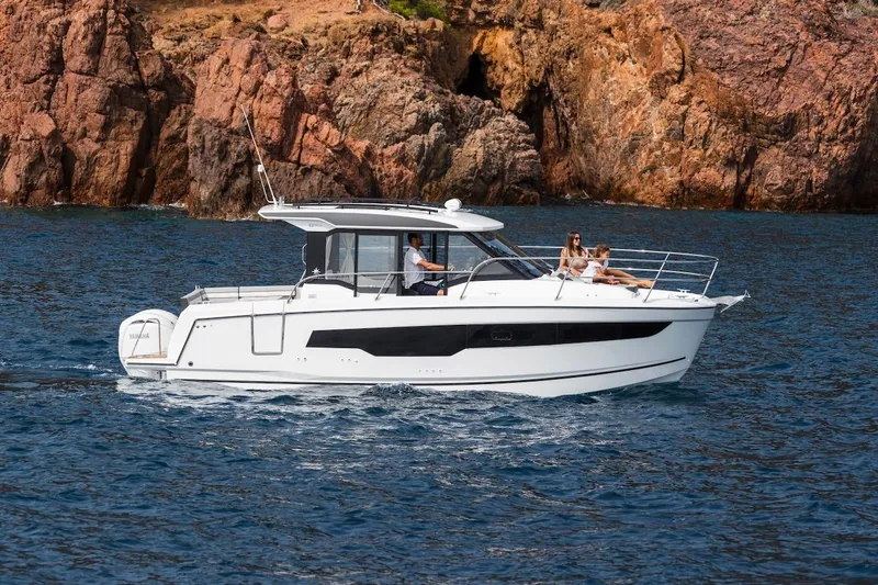 The Image of 2025 Jeanneau NC 895 Series 2 cruising near rocky coastline. - 18