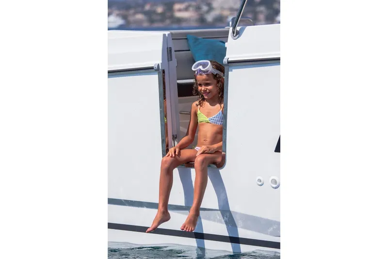 Slide: The Image of Child sitting on 2025 Jeanneau NC 895 Series 2 boat, wearing swimwear and goggles. - 55