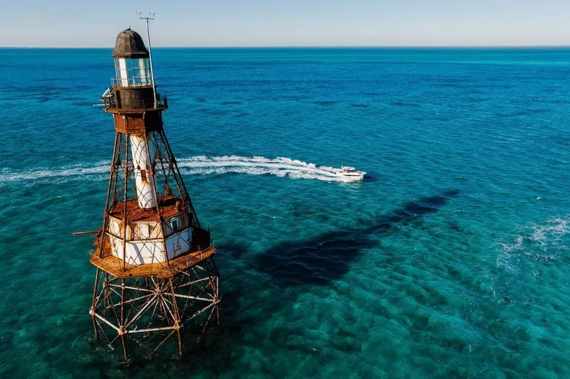 Slide: The Image of Aerial view of Jeanneau NC 895 Series 2 boat near a rusted lighthouse, 2025 model. - 76