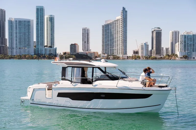 Slide: The Image of 2025 Jeanneau NC 895 Series 2 boat cruising near city skyline on calm water. - 86
