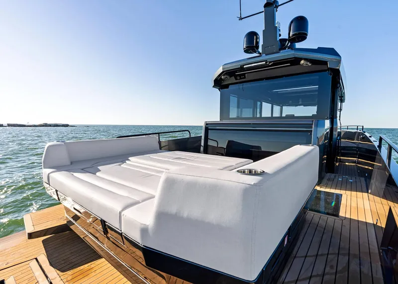 Slide: The Image of 2025 XO Boats EXPLR 44 yacht with luxurious deck seating on open water. - 15