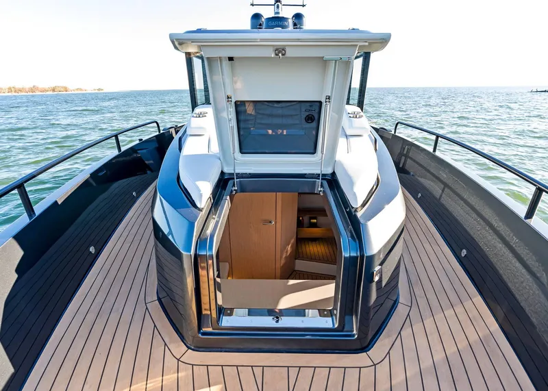 Slide: The Image of 2025 XO Boats EXPLR 44 yacht with open cabin door, sleek deck design, and ocean view. - 25