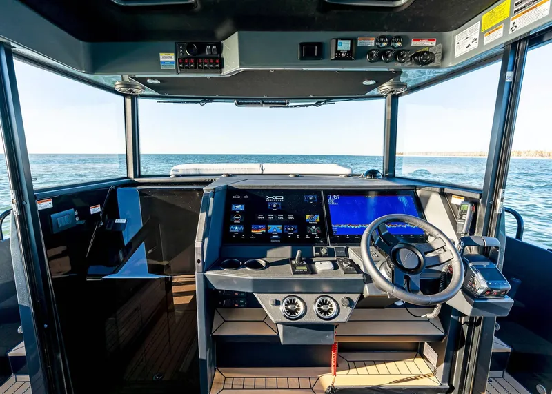 Slide: The Image of 2025 XO Boats EXPLR 44 cockpit with advanced navigation systems and ocean view. - 27