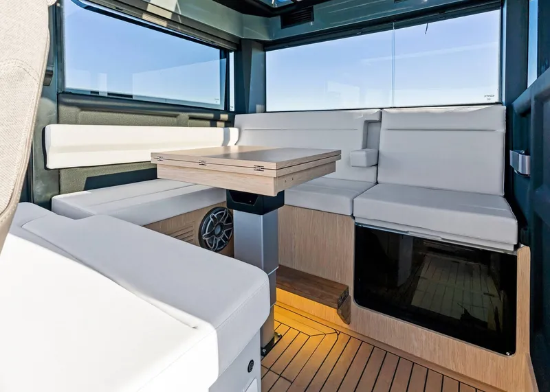 Slide: The Image of Interior of 2025 XO Boats EXPLR 44, featuring modern seating and wooden table. - 28