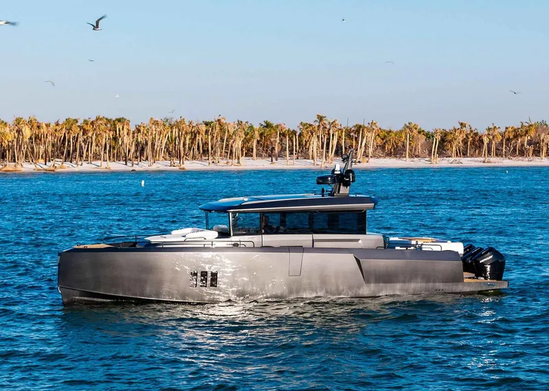 Slide: The Image of 2025 XO Boats EXPLR 44 yacht cruising near a tropical shoreline with palm trees. - 3