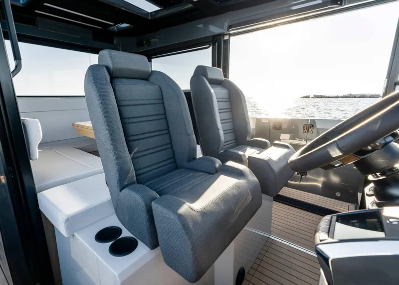 Slide: The Image of Interior of 2025 XO Boats EXPLR 44, featuring modern seating and steering wheel. - 30