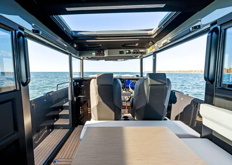 Slide: The Image of 2025 XO Boats EXPLR 44 interior with ocean view, featuring modern seating and navigation controls. - 33