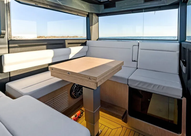 Slide: The Image of Interior of 2025 XO Boats EXPLR 44, featuring modern seating and a wooden table. - 34