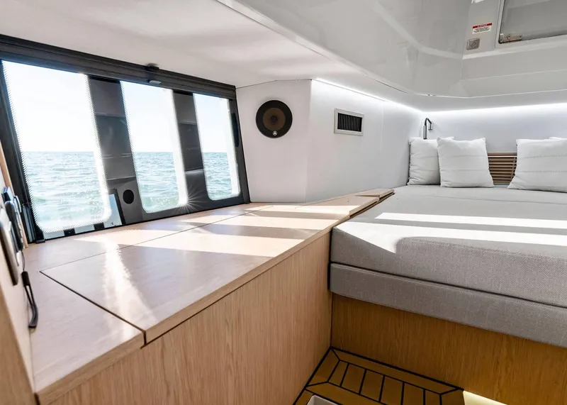 Slide: The Image of Modern interior of 2025 XO Boats EXPLR 44 with ocean view and cozy bedding. - 35