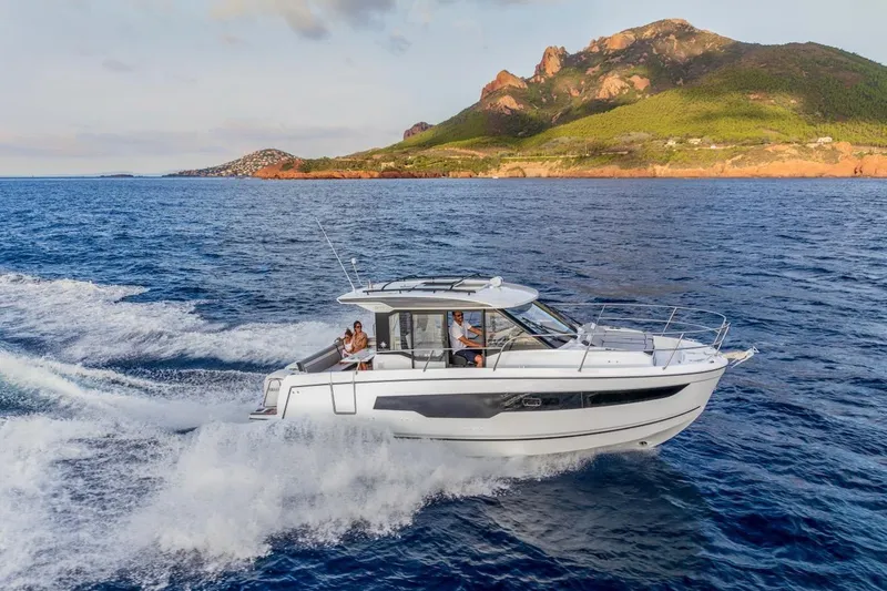 Slide: The Image of 2025 Jeanneau NC 895 Series 2 cruising on blue ocean near scenic coastline. - 44