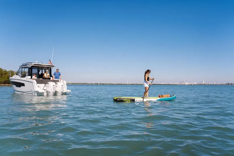 Slide: The Image of 2025 Jeanneau NC 895 Series 2 boat on water with paddleboarder nearby. - 86