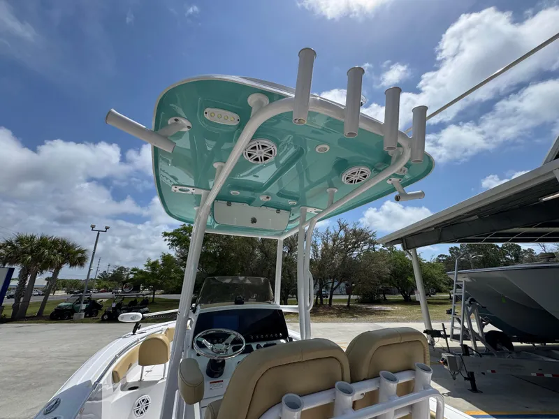 Slide: The Image of 2023 Sportsman Open 212 Center Console boat with teal T-top and rod holders. - 37