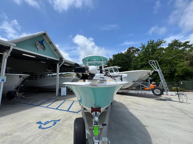 Slide: The Image of 2023 Sportsman Open 212 Center Console boat on trailer, parked outside a marina. - 7
