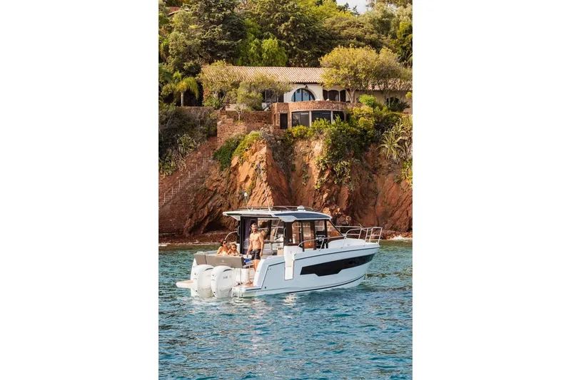 Slide: The Image of 2025 Jeanneau NC 895 Series 2 cruising near a scenic coastal villa. - 26