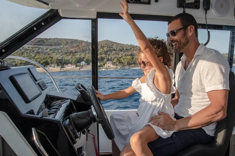 Slide: The Image of Father and daughter enjoying a ride on a 2025 Jeanneau NC 895 Series 2 boat. - 33
