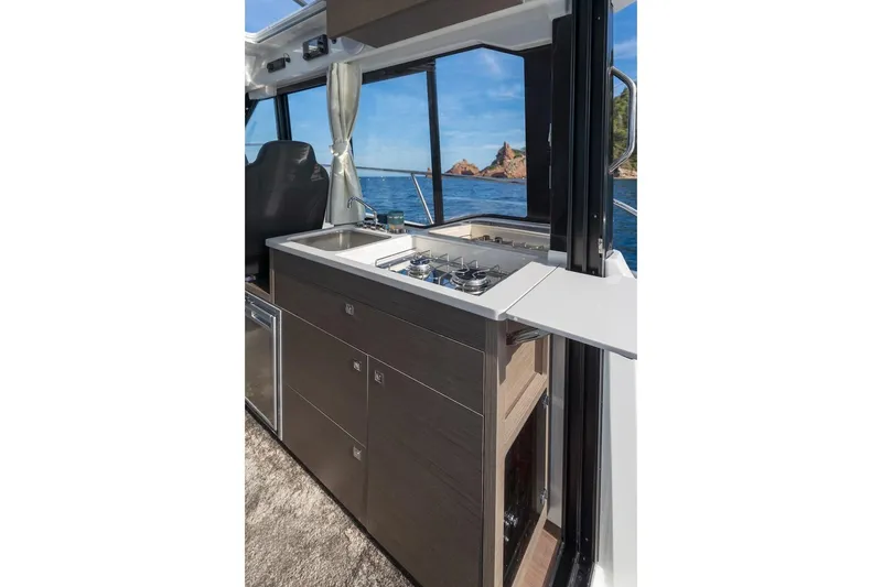 Slide: The Image of 2025 Jeanneau NC 895 Series 2 boat kitchen with stove, sink, and ocean view. - 59