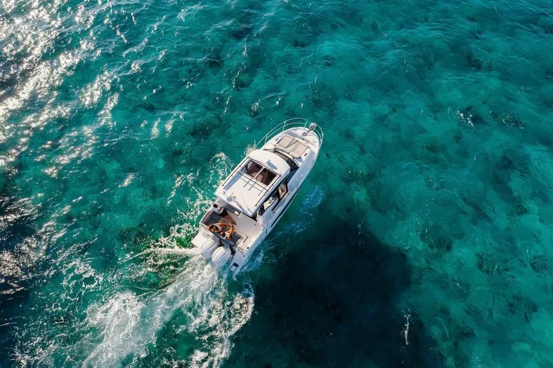 Slide: The Image of Aerial view of 2025 Jeanneau NC 895 Series 2 cruising on clear turquoise waters. - 70