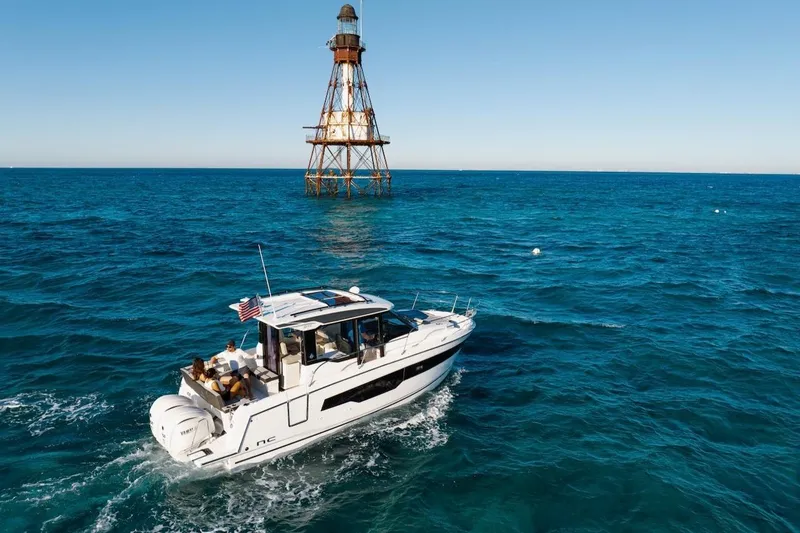 Slide: The Image of 2025 Jeanneau NC 895 Series 2 cruising near a lighthouse on open blue waters. - 74