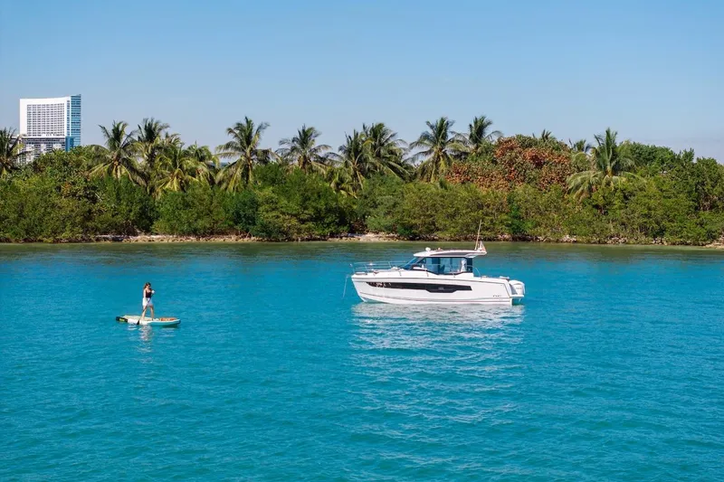 Slide: The Image of 2025 Jeanneau NC 895 Series 2 boat on blue water near tropical shoreline. - 83
