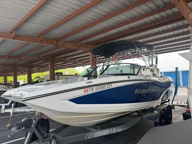 Slide: The Image of 2015 MasterCraft X23 boat on trailer under shelter. - 10