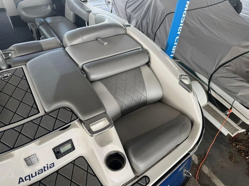 Slide: The Image of 2015 MasterCraft X23 boat interior with gray seating and cup holder. - 12