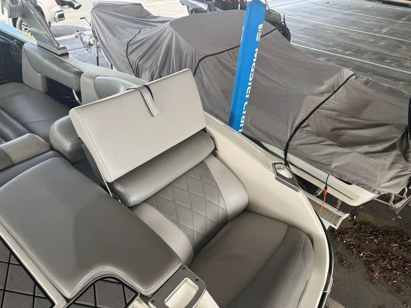 Slide: The Image of 2015 MasterCraft X23 boat interior with gray seating and covered boats in the background. - 14