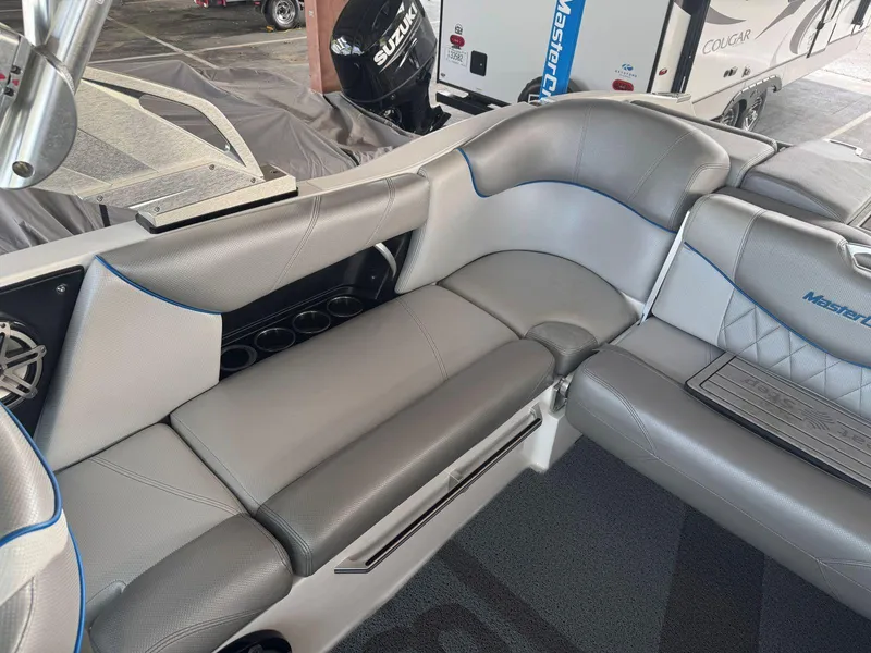 Slide: The Image of 2015 MasterCraft X23 boat interior with gray seating and cup holders. - 18
