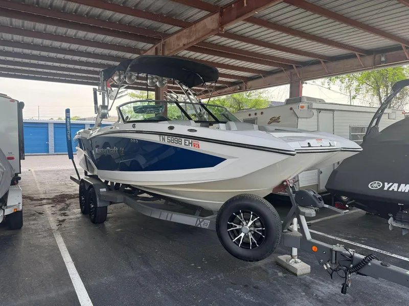 Slide: The Image of 2015 MasterCraft X23 boat on trailer under a covered parking area. - 2