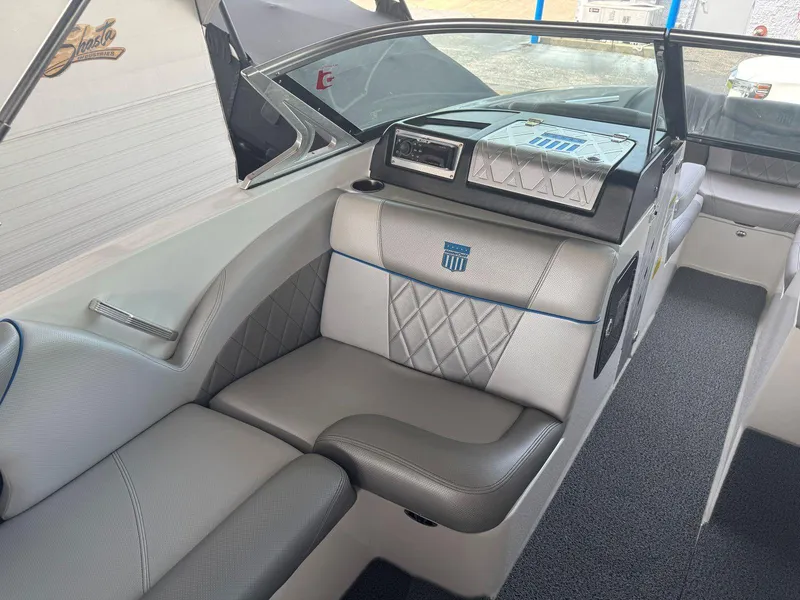 Slide: The Image of 2015 MasterCraft X23 boat interior with gray seating and modern dashboard. - 20