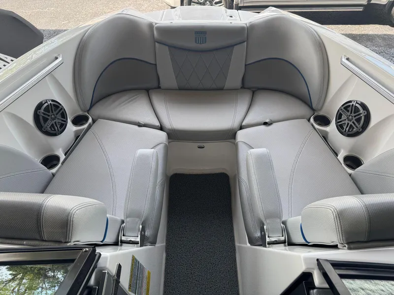 Slide: The Image of 2015 MasterCraft X23 boat interior with gray seating and built-in speakers. - 29
