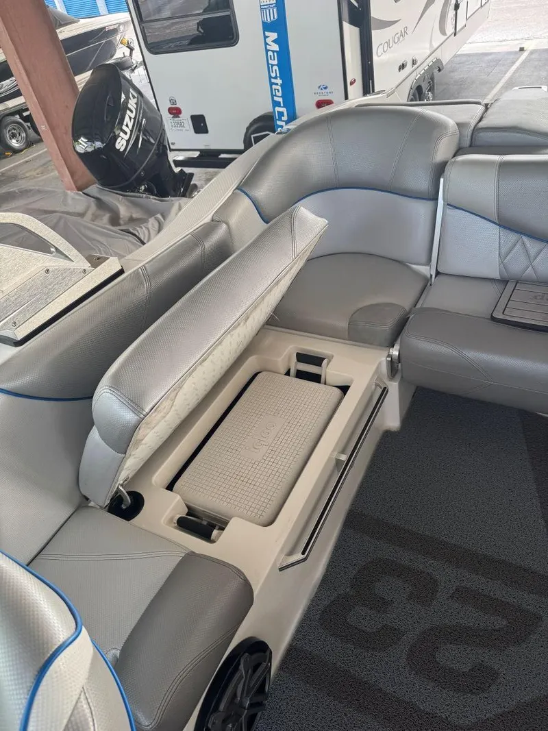 Slide: The Image of 2015 MasterCraft X23 boat interior with open storage compartment and gray seating. - 36