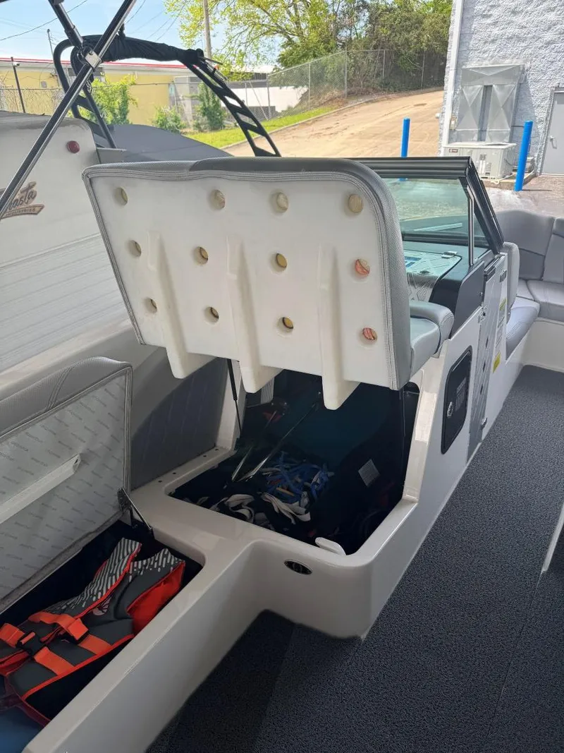 Slide: The Image of 2015 MasterCraft X23 boat interior with open storage compartment and visible seating. - 38