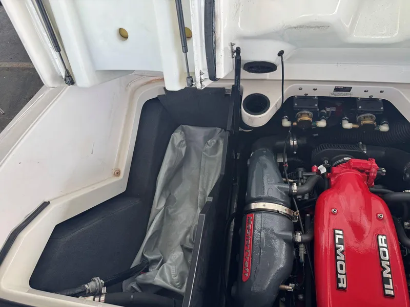 Slide: The Image of 2015 MasterCraft X23 engine compartment with Ilmor engine, showcasing detailed components and storage area. - 43