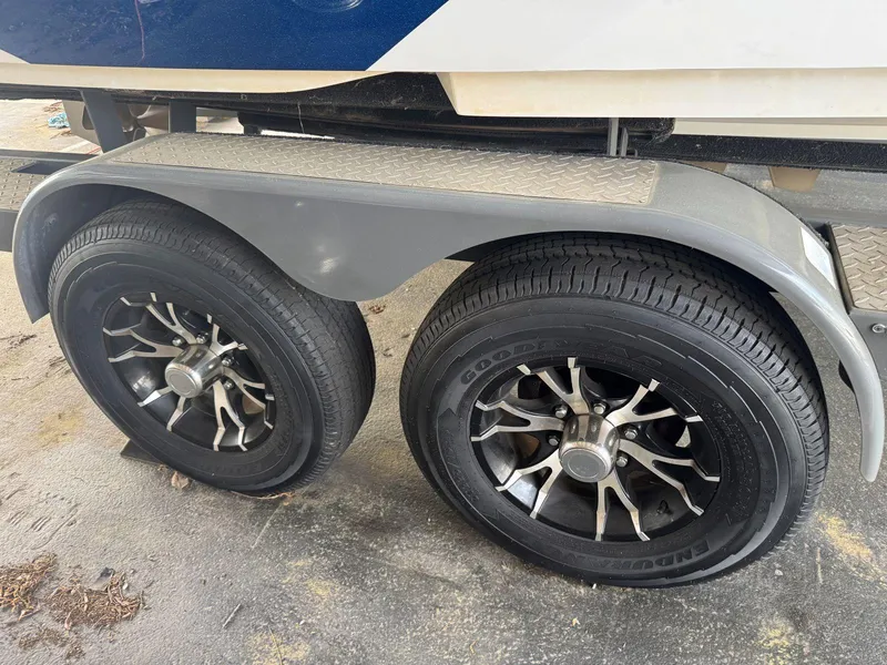 Slide: The Image of 2015 MasterCraft X23 trailer wheels with black rims and silver accents. - 47