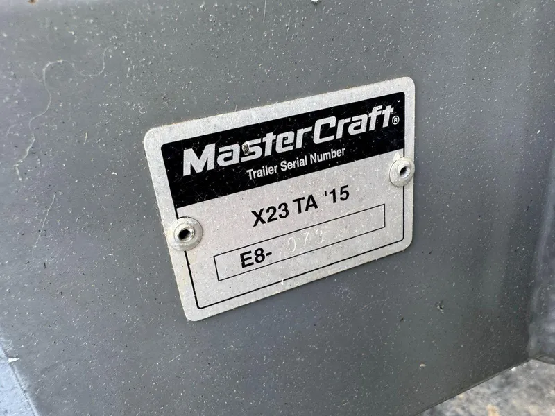 Slide: The Image of MasterCraft X23 2015 trailer serial number plate on gray surface. - 48