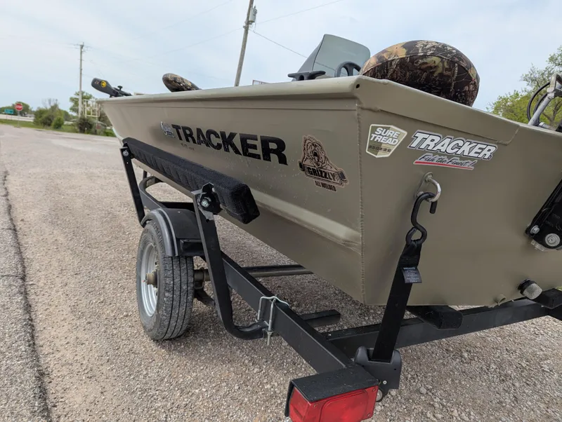 Slide: The Image of 2022 Tracker Grizzly 1648 SC boat on trailer, parked on a gravel road. - 30