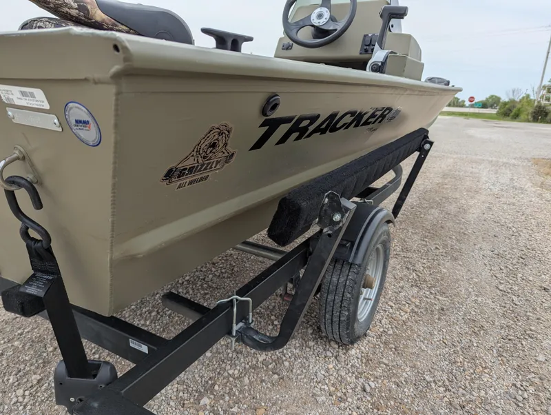 Slide: The Image of 2022 Tracker Grizzly 1648 SC boat on trailer, side view, parked on gravel. - 32