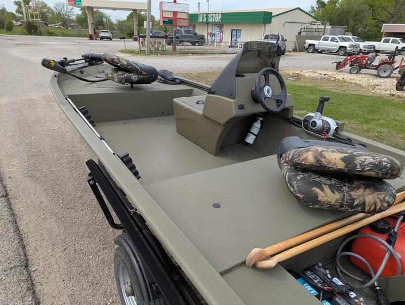 Slide: The Image of 2022 Tracker Grizzly 1648 SC boat with camo seats and steering console, parked on roadside. - 41