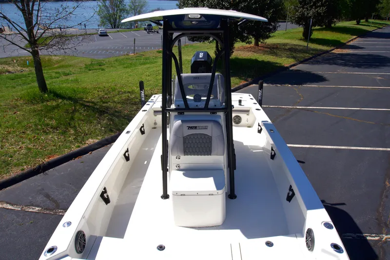 Slide: The Image of 2025 Pathfinder 2500 Hybrid boat, white interior, parked near a lake. - 11