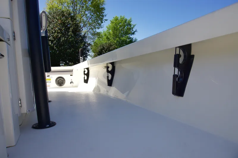 Slide: The Image of 2025 Pathfinder 2500 Hybrid boat interior with rod holders, under clear blue sky. - 17